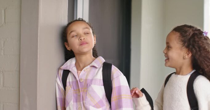 African American teen girls leaning at column, turning as friend walking with backpacks to school