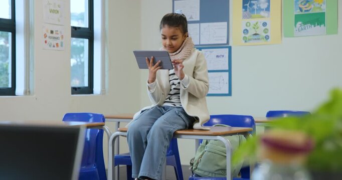 African American female child tapping, scrolling tablet on desk at window, noticing motion, smiling