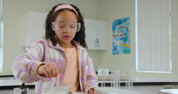 African American teen spotting tray, drawing yellow fluid with pipette into tubes, prepping samples