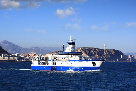 Trauler fishing boat sailing along the Mediterranean coast of Spain. 