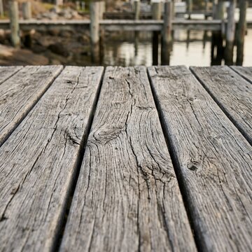 Weathered Wooden Dock Surface with Blurred Water and Pilings Background.