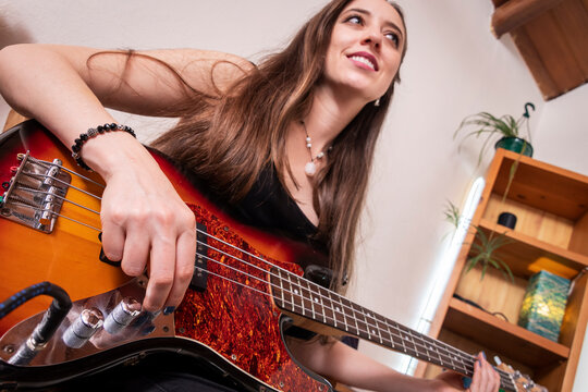 Young Female Bass Guitarist Practicing Music with Creative Perspective