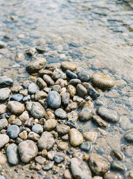Close up of smooth river stones and clear flowing water.