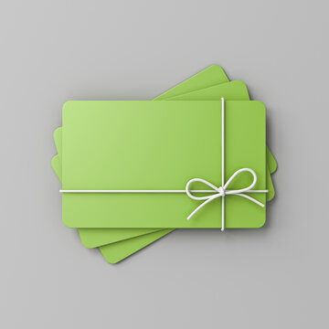 Stack of blank green pastel color business gift cards mock up with white rope bow isolated on gray background with shadow minimal conceptual 3D rendering