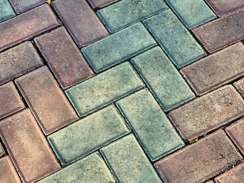 Colorful brick paving stones arranged in herringbone pattern