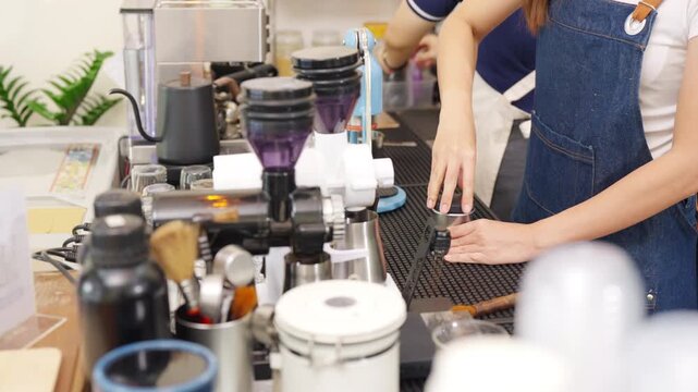 Small business entrepreneur coffee shop cafe restaurant. Asian woman barista using manual espresso maker making freshly brewed coffee on bar counter. Waitress serving beverage drink to customer.