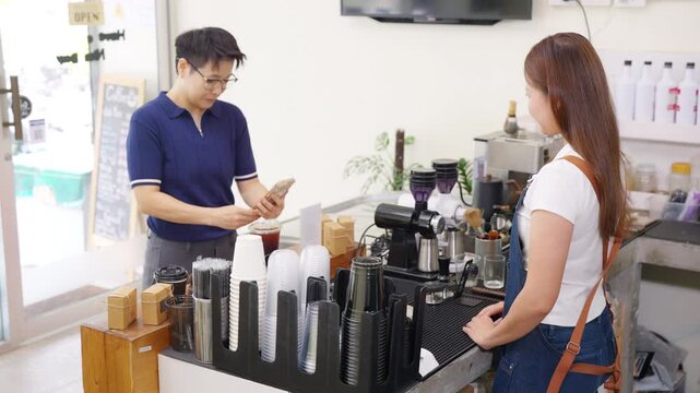 Cashless qr code payment by smartphone at coffee shop, customer scanning mobile payment electronic banking while cafe owner serving takeaway coffee, digital transaction and small business technology