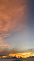 Fototapeta premium Dramatic Orange Sunset Sky Above Clouds And Mountain Peaks