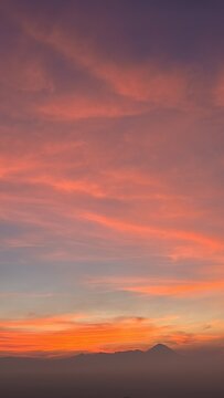 Vibrant Sunset Sky With Orange And Pink Clouds Over Mountains