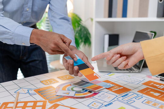 A UX design team collaborates with wireframes, interface cards, color palettes, and mobile app prototypes to improve user experience, design systems, product strategy, and digital innovation.