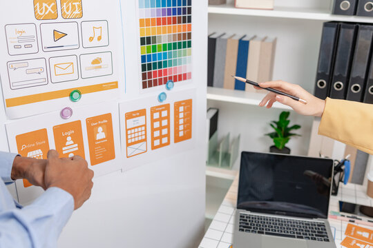 A UX design team reviews interface layouts, shares feedback, confirms design decisions, and celebrates project progress, strengthening collaboration, product strategy, and user centered innovation.