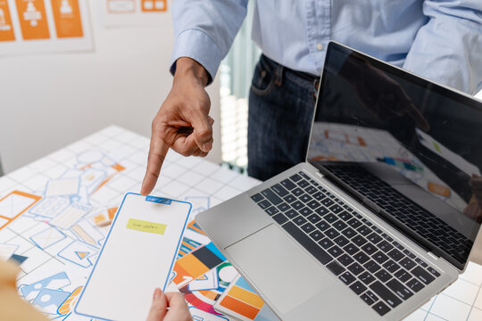 A UX design team collaborates with wireframes, interface cards, color palettes, and mobile app prototypes to improve user experience, design systems, product strategy, and digital innovation.