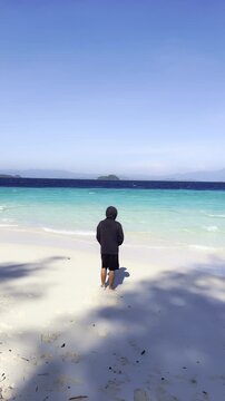 Man Standing on a Tropical White Sand Beach