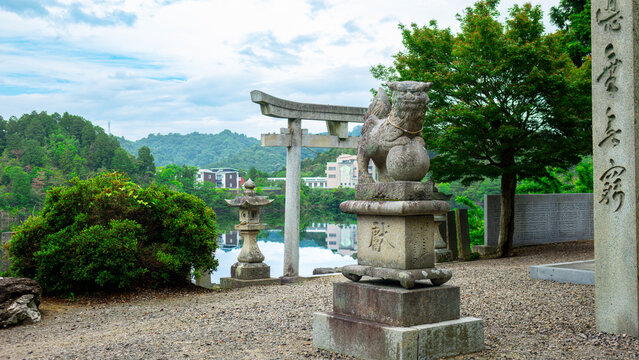 Cinematic View of Shinto Shrine Torii Gate and Komainu Overlooking Peaceful Pond in June, Funaki, Niihama, Ehime, Japan
