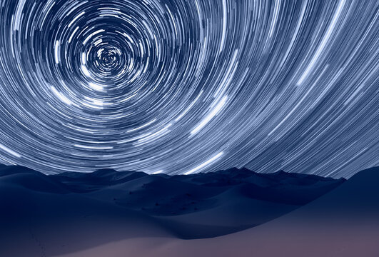 Long exposure photo of night sky star trail over the sand dunes of Sahara Desert - Sahara, Morocco
