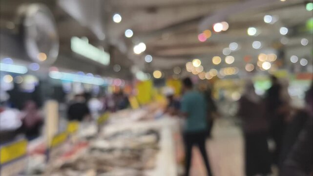 Blurred indoor shot of crowded shopping mall hallway during weekend holiday sale activity
