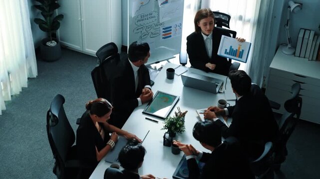Top view of smart executive manager looking at financial graph while skilled business team give high five and clapping hands to celebrate increasing sales. Successful team shaking hands. Directorate.