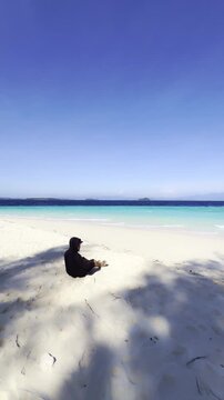 Person Sitting on a Tropical Beach