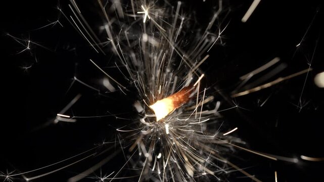 Sparkler Emitting Glowing Sparks Against Dark Background in Macro Detail 4K