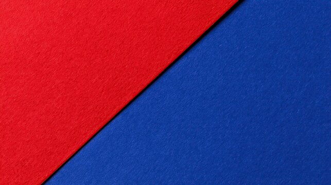 Minimalist geometric background divided diagonally into matte red and blue paper sections creating simple clean two-color composition