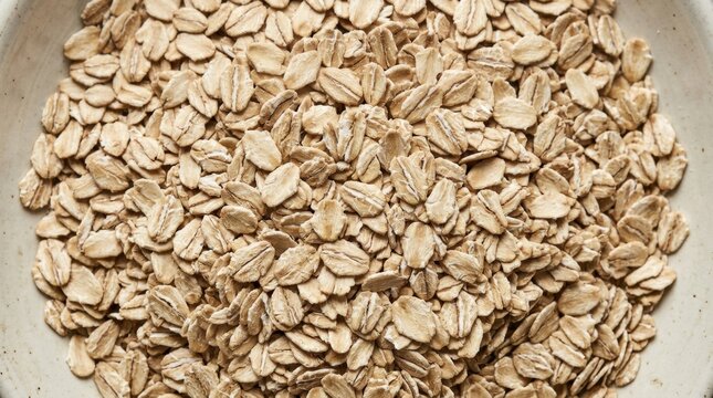 Top-down view of uncooked light brown rolled oats texture: Close-up shot showcasing the natural