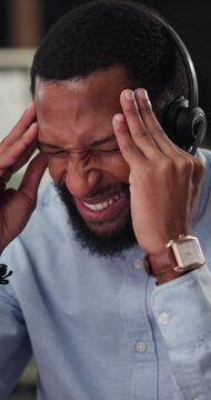 Consulting, man or headache in callcenter at night for help desk overload, ticket backlog or burnout. Black person, agent and stress with computer for hotline queue, migraine massage or shift fatigue