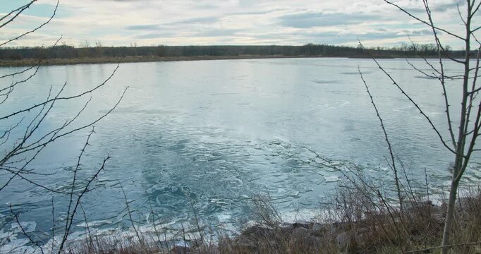 Frozen Lake Behind Thorny Branches under Grey Cloud