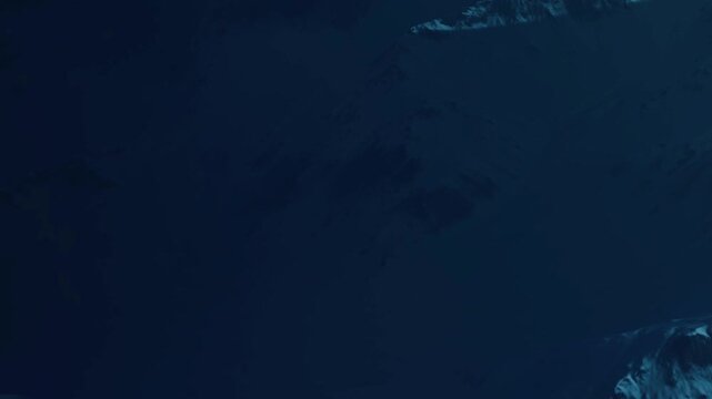 Deep ocean water with dark areas and bright surfaces on the ocean floor. The play of light and shadow creates an interesting landscape under the sea.