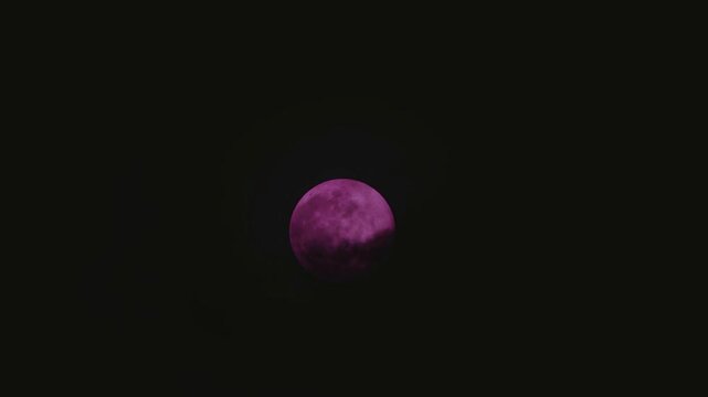 Surreal pop art purple moon with dark clouds floating past on a windy night creating spooky abstract dreamcore landscape
