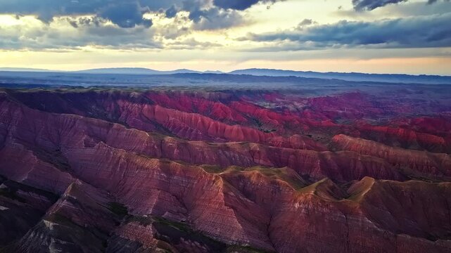 Aerial view of multicolored sedimentary layers of Danxia landforms at sunset in Xinjiang, China