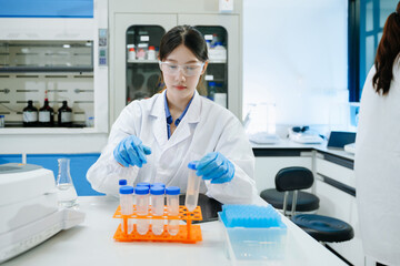 Fototapeta premium Modern medical research laboratory. female scientist working with micro pipettes analyzing biochemical samples, advanced science chemical laboratory