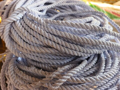 Large bundle of twisted white nylon rope coiled tightly together. Durable industrial cordage material photo for hardware supplies, marine equipment, packaging, or DIY craft concepts.