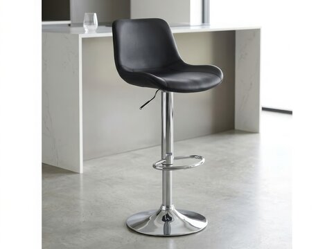 Modern black leather bar stool with a shiny chrome metal base and adjustable height standing in a contemporary kitchen interior