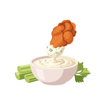 Fried chicken buffalo wing dipped in blue cheese sauce with celery