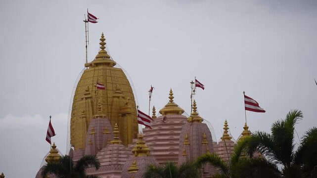 Spiritual view of sacred Swaminarayan Temple at Poicha, Nilkanth Dham, featuring ornate temple spires and divine architecture under a cloudy sky, reflecting Hindu faith, devotion and peace in Gujarat.