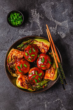 Delicious meatballs served with cooked cabbage bok choy.