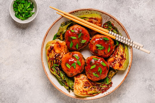 Delicious meatballs served with cooked cabbage bok choy.