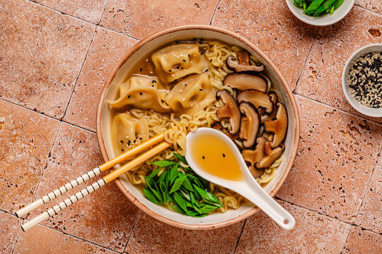 Delicious bowl of noodles with dumplings and mushrooms