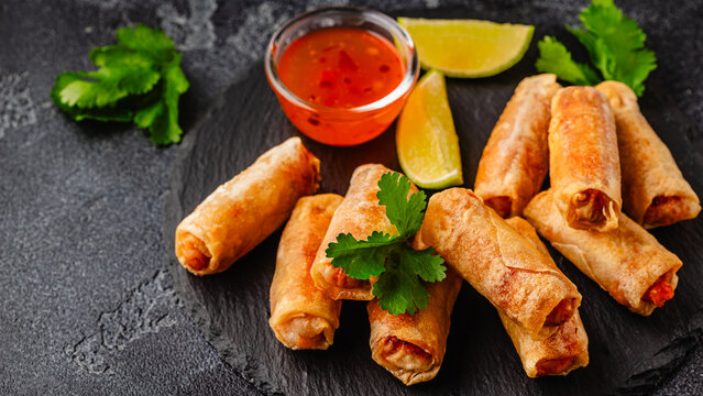 Fried spring rolls served with sauce and lime