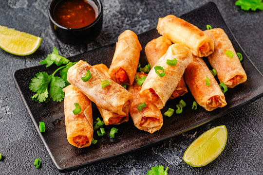 Fried spring rolls served with sauce and lime