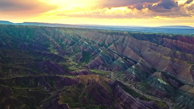Aerial view of multicolored sedimentary layers of Danxia landforms at sunset in Xinjiang, China