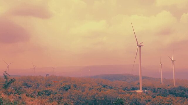 Conceptual abstract of wind turbines wind farm with muted pink and orange color grading