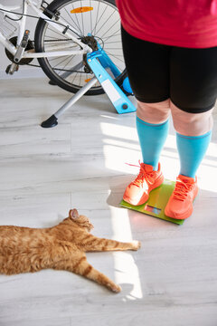 Person checking weight on scale before home training