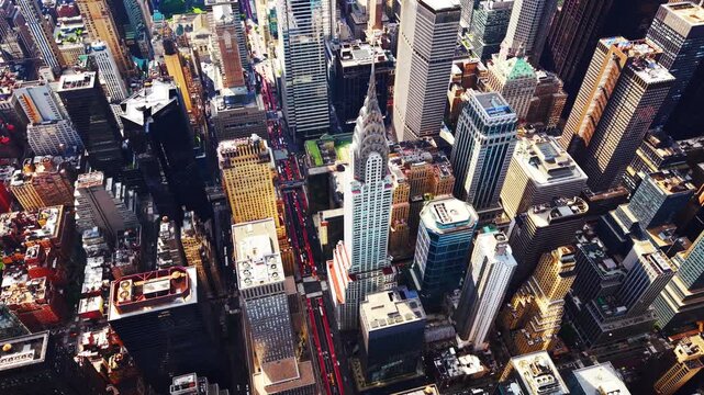 Aerial view of midtown skyscraper architecture, Manhattan, New York. High drone angle over dense urban block, deep shadow and busy road below.
