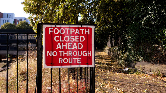 Footpath closed ahead, sign, red, warning, notice, warning sign notice on metal fence outdoors