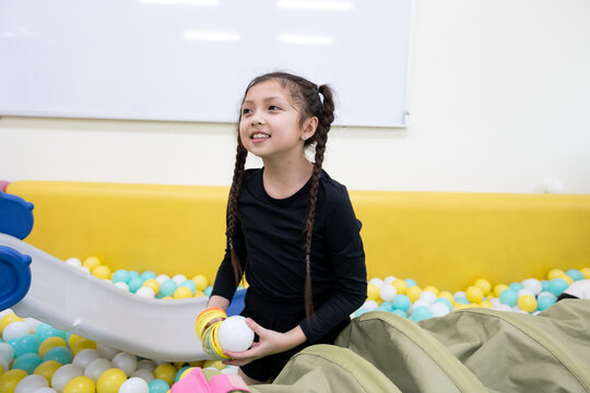 Girl playing with spring toy in ball pit