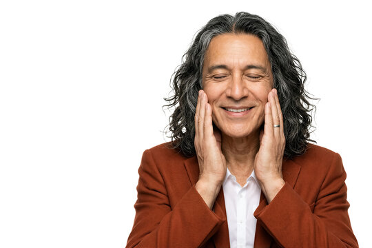 Man smiles while touching his face with eyes closed. Bright white background makes subject stand out. Concept of wellness, self-care, relaxation