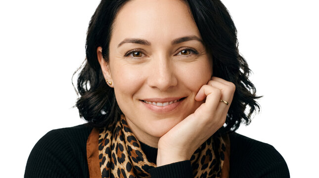 Woman smiles while resting her chin on hand in studio setting. Bright white background highlights her cheerful expression. Concept of personal branding, portraiture, lifestyle