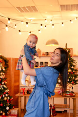Obraz premium Happy Family with Baby Celebrating Christmas at Home, Parents Enjoying Cozy Holiday Season Near Christmas Tree, Festive Family Tradition, Love, Togetherness and Winter Celebration