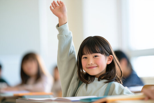 ランドセルを背負い、教室で穏やかに微笑みながら手を挙げる日本人の小学生の女の子